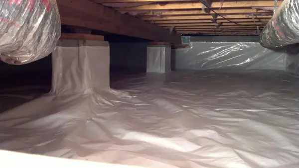 A clean, dry crawl space with a new vapor barrier installation.