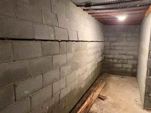 A significant horizontal crack in a basement cinder block foundation wall.