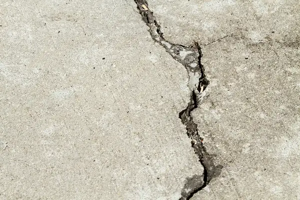 Ground Up Foundation Repair, Waterproofing and Concrete Leveling inspecting a prominent, jagged concrete floor crack.