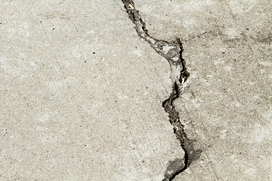 A jagged crack running across an exterior concrete slab.