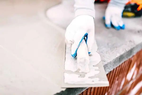 Ground Up Foundation Repair, Waterproofing and Concrete Leveling applying and finishing fresh concrete with a trowel.