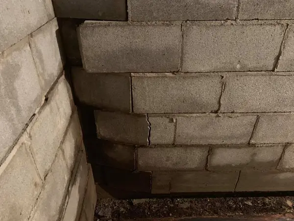 Ground Up Foundation Repair, Waterproofing and Concrete Leveling inspecting a severely bowing concrete block basement wall.