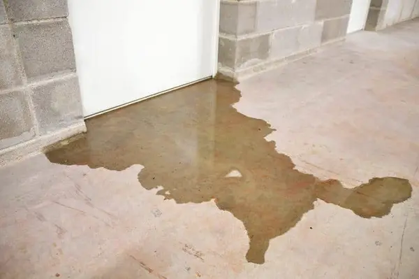 Basement flooding with standing water on a concrete floor.