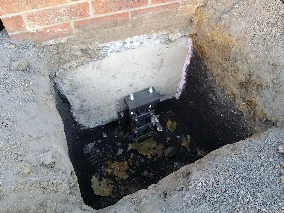 Ground Up Foundation Repair, Waterproofing and Concrete Leveling installing a new foundation pier for structural stabilizatio