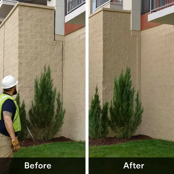 A technician inspecting a vertical crack in a commercial building foundation.
