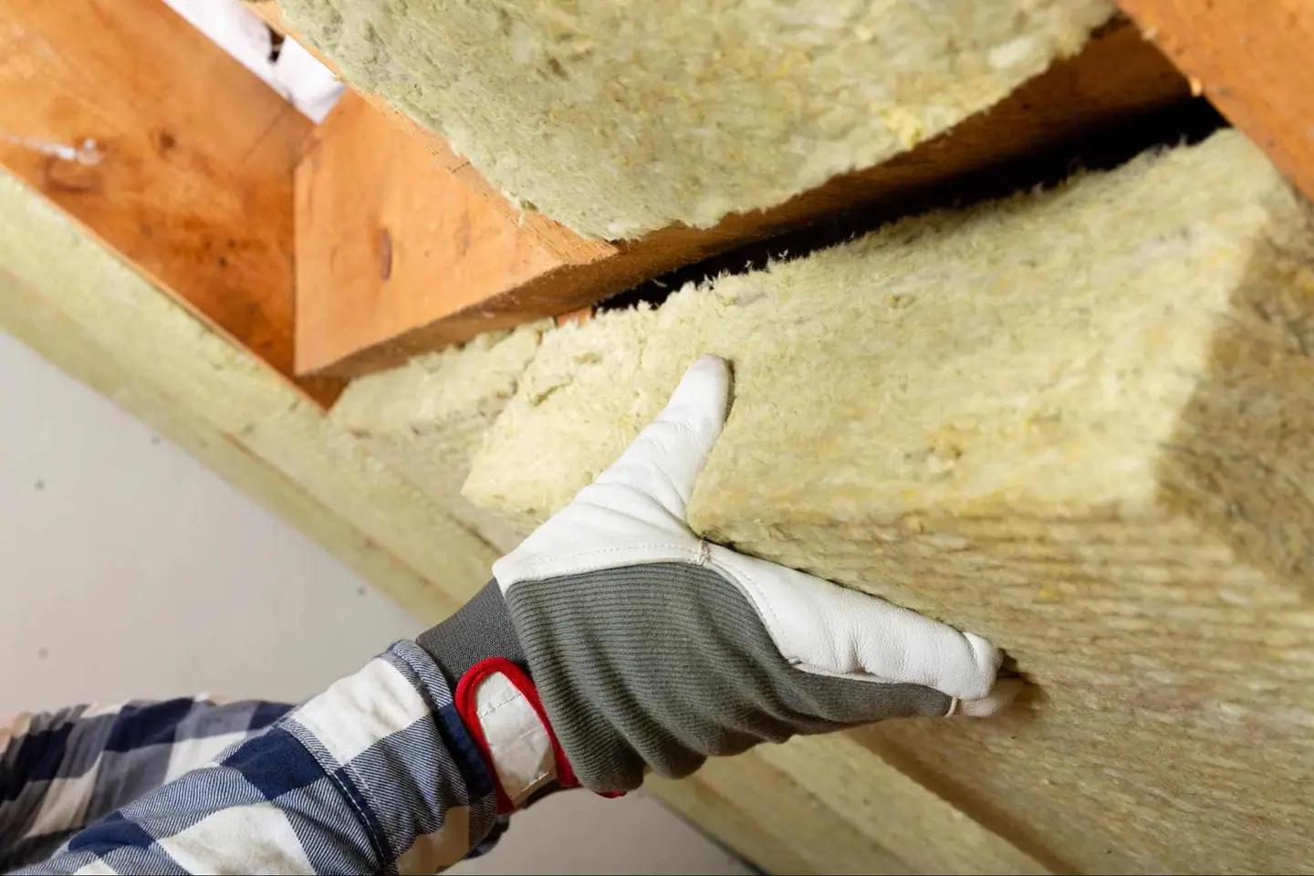 Ground Up Foundation Repair, Waterproofing and Concrete Leveling installing new crawl space insulation between floor joists.