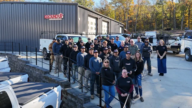 Ground Up Foundation Repair team members outside the company office with their service trucks.