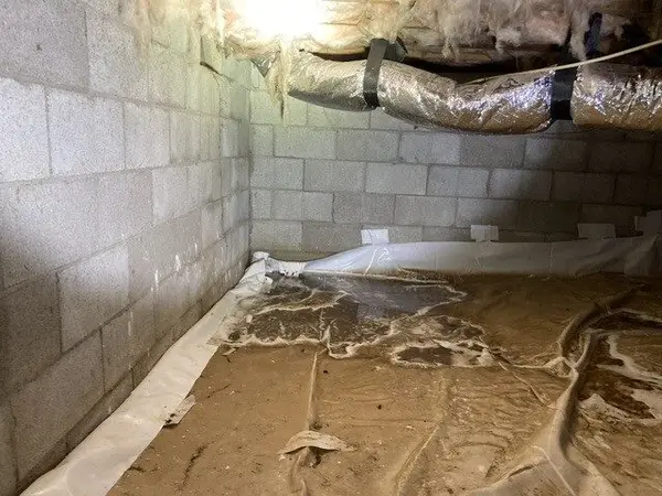 Ground Up Foundation Repair, Waterproofing and Concrete Leveling inspecting standing water and a failed vapor barrier