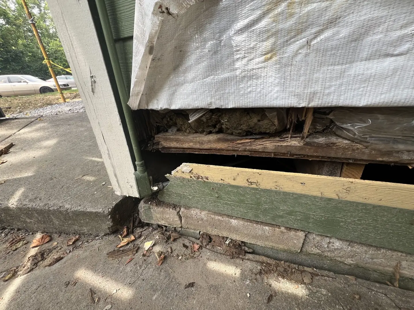 Ground Up Foundation Repair, Waterproofing and Concrete Leveling inspecting rotted wood and damaged sill plate near house