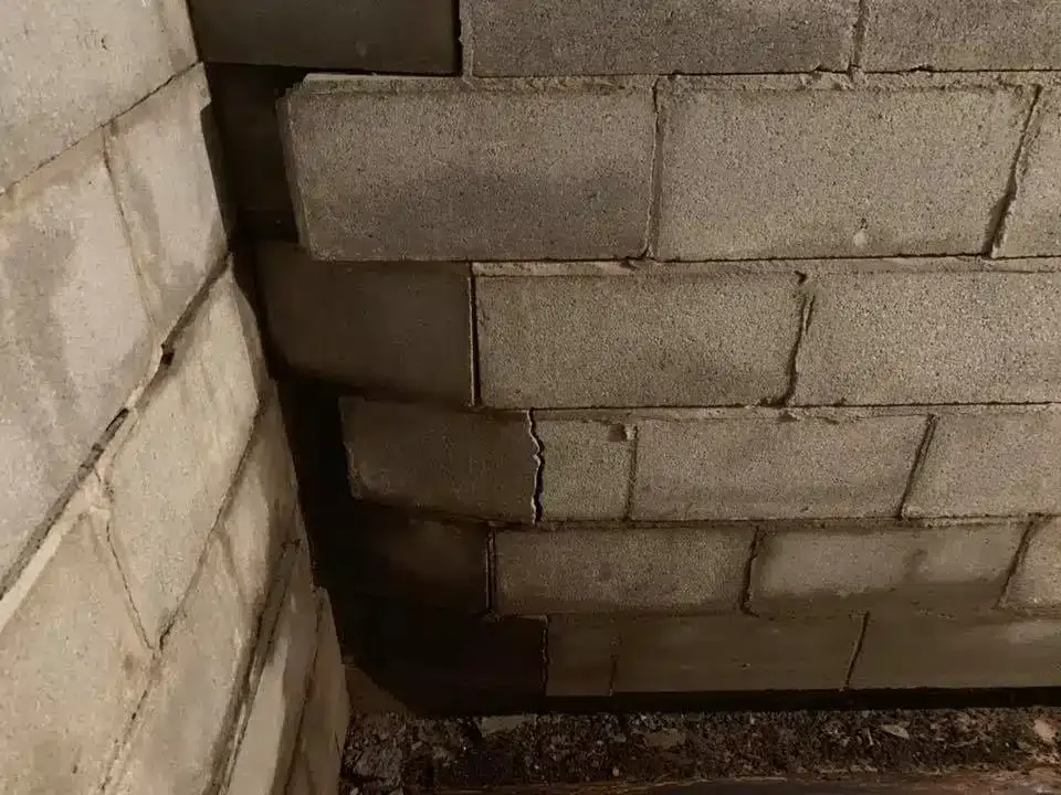Ground Up Foundation Repair, Waterproofing and Concrete Leveling inspecting severe bowing and stair-step cracks