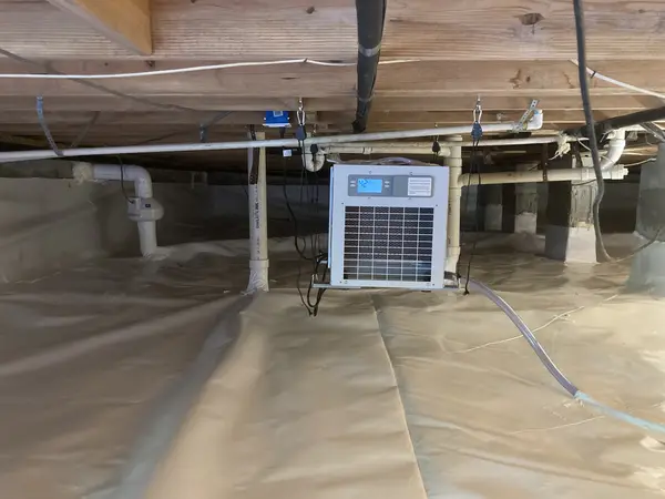 Ground Up Foundation Repair, Waterproofing and Concrete Leveling installing a crawl space dehumidifier and vapor barrier.