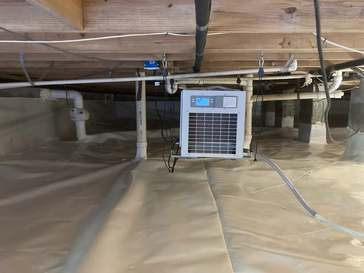 Ground Up Foundation Repair, Waterproofing and Concrete Leveling installing a crawl space dehumidifier and vapor barrier.