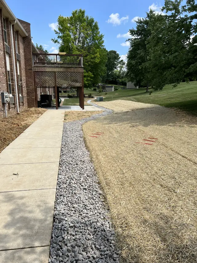 Ground Up Foundation Repair, Waterproofing and Concrete Leveling installing an exterior gravel drainage channel to manage