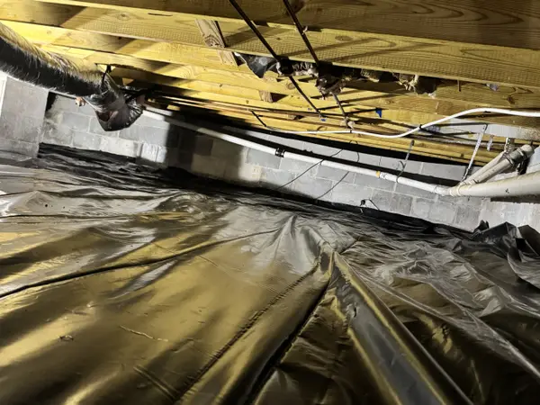 Ground Up Foundation Repair, Waterproofing and Concrete Leveling installing a vapor barrier in a crawl space.